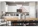 Bright kitchen with white cabinets, granite countertops, and a decorative dining table at 2489 Alto St, Fort Lupton, CO 80621