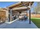 Outdoor covered patio with a grilling area, dining table, and green backyard at 7120 Galapago St, Denver, CO 80221