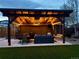 Outdoor covered patio area at dusk featuring a ceiling fan, lights, and ample seating at 7120 Galapago St, Denver, CO 80221