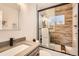 This bathroom includes a glass shower with white and wood-look tiles and a vanity at 7120 Galapago St, Denver, CO 80221
