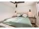 A bright bedroom features wood-look floors, ceiling fan, and two decorative sconce lights at 7120 Galapago St, Denver, CO 80221