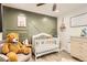 This Bedroom includes a crib, wood-look floors, and an olive green accent wall at 7120 Galapago St, Denver, CO 80221