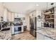 Modern kitchen featuring stainless steel appliances, granite countertops, and custom cabinets at 7120 Galapago St, Denver, CO 80221