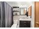 Bathroom featuring a marble vanity, chrome fixtures, three-light vanity, toilet and tiled shower at 10298 W Dartmouth Ave, Lakewood, CO 80227