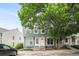 Charming townhome exterior featuring a mature shade tree and well-maintained landscaping at 10298 W Dartmouth Ave, Lakewood, CO 80227