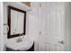 Close-up of a quaint bathroom with a framed mirror and white fixtures at 7870 W 87Th Dr # J, Arvada, CO 80005