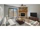 Inviting living room featuring a stone fireplace and sliding glass door to the outside at 7870 W 87Th Dr # J, Arvada, CO 80005