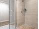 Modern bathroom with glass shower featuring pebble floor and tile walls at 2952 S Delaware St, Englewood, CO 80110