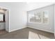 Minimalist bedroom featuring neutral carpeting, a spacious window, and bright, neutral walls at 2952 S Delaware St, Englewood, CO 80110