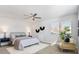 Well-lit bedroom with a ceiling fan, accent wall decorations, a cozy chair, and a neutral color scheme at 2952 S Delaware St, Englewood, CO 80110