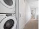 Convenient in-unit laundry featuring a stacked washer and dryer, with a hallway view at 2952 S Delaware St, Englewood, CO 80110