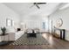 Spacious living room with modern furnishings, a ceiling fan, and large windows at 2952 S Delaware St, Englewood, CO 80110
