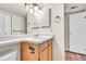 This bathroom features a wood vanity and bright lighting fixture at 8335 Fairmount Dr # 102, Denver, CO 80247