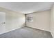 Bright and airy bedroom with neutral carpet and paint, and a view from the window at 8335 Fairmount Dr # 102, Denver, CO 80247