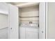 A tidy laundry closet featuring a stacked washer and dryer, and built in shelving for storage at 8335 Fairmount Dr # 102, Denver, CO 80247