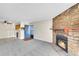 View of the living room with a stone fireplace, kitchen, and exterior door at 8335 Fairmount Dr # 102, Denver, CO 80247