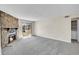 Spacious living room with a cozy stone fireplace and sliding glass doors to balcony at 8335 Fairmount Dr # 102, Denver, CO 80247