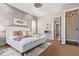 Well-lit primary bedroom with a bed, accent wall, ceiling fan, and access to a large ensuite bathroom at 27365 E Jamison Cir, Aurora, CO 80016