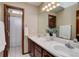 Bright bathroom featuring dual sinks, a large mirror, and a shower at 10032 Astoria Ct, Lone Tree, CO 80124
