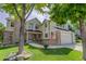 Inviting two-story home with manicured lawn, brick accents, and charming front porch and American flag at 10032 Astoria Ct, Lone Tree, CO 80124