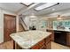 Bright kitchen with a granite island, dark appliances, and views into the breakfast nook and living room at 10032 Astoria Ct, Lone Tree, CO 80124