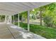 This covered outdoor patio features a concrete floor and white support beams, ideal for enjoying the beautiful lawn and greenery at 10032 Astoria Ct, Lone Tree, CO 80124