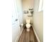 Bright half bathroom featuring wood-look flooring and decorative wall shelves at 16611 E 119Th Ave # E, Commerce City, CO 80022