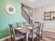 Charming dining area with green accent wall, a staircase, and modern decor at 16611 E 119Th Ave # E, Commerce City, CO 80022