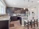 Modern kitchen featuring an island with bar seating, stainless steel appliances, and wood floors at 16611 E 119Th Ave # E, Commerce City, CO 80022