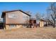 Split-level home featuring a wood and brick exterior, complemented by a cozy front porch at 860 S 7Th Ave, Brighton, CO 80601