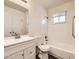 A bright bathroom boasts a shower-tub combo with modern fixtures and a white vanity at 1922 S Oswego Way, Aurora, CO 80014