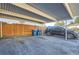 Carport featuring a parked SUV, trash receptacles, and a sturdy wooden fence at 1922 S Oswego Way, Aurora, CO 80014