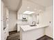 Updated kitchen featuring white cabinets, a peninsula counter, and stainless steel appliances at 1922 S Oswego Way, Aurora, CO 80014