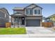 Two-story house with gray siding, stone accents, and a two-car garage at 27500 E Cedar Pl, Aurora, CO 80018