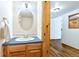 Cozy half-bathroom with blue countertop, oak vanity, and an oval mirror over the sink at 2650 S Vaughn Way # B, Aurora, CO 80014