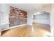 Bright living area boasts an exposed brick wall, hardwood floors, and ample natural light at 108 W Byers Pl # G4, Denver, CO 80223