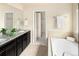 A bathroom boasts granite countertop, dark cabinets, tile flooring, soaking tub and closet at 10465 Evansville Cir, Parker, CO 80134