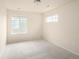 A well lit bedroom with two windows, neutral colored walls, and carpet flooring at 10465 Evansville Cir, Parker, CO 80134