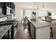 Modern kitchen with stainless steel appliances, granite countertops, and adjacent living area at 10465 Evansville Cir, Parker, CO 80134