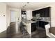 Modern kitchen with dark cabinets, stainless steel appliances, and island with bar seating at 10465 Evansville Cir, Parker, CO 80134