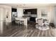 Well-lit kitchen with black cabinetry, stainless appliances, and an adjacent dining area at 10465 Evansville Cir, Parker, CO 80134