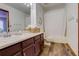 Well-lit bathroom boasts wood-look floors, ample counter space, and a shower-tub combo at 10059 Granite Hill Dr, Parker, CO 80134