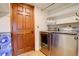 Laundry room with modern washer/dryer, wood door and shelving for storage at 10059 Granite Hill Dr, Parker, CO 80134