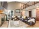 Bright and inviting living room with vaulted ceilings, brick fireplace, and plush leather seating at 10059 Granite Hill Dr, Parker, CO 80134