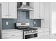 Modern kitchen featuring stainless steel appliances and a stylish blue tile backsplash at 2676 W 68Th Ave, Denver, CO 80221