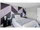 A modern bedroom with a geometric wall design, black nightstands, and a queen bed at 8721 W 86Th Ave, Arvada, CO 80005