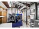 Efficient laundry area featuring modern, front-load washer and dryer with exposed ductwork and utility connections at 8721 W 86Th Ave, Arvada, CO 80005