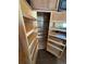 Kitchen pantry featuring natural wood and pull-out shelves for convenience at 8721 W 86Th Ave, Arvada, CO 80005