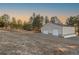 Large white storage building with dual garage doors and mature trees and landscaping at 7076 Inspiration Dr, Parker, CO 80138