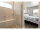 Modern tiled shower with a glass door and a built-in bench, located adjacent to a cozy bedroom at 7022 Homeplace St, Castle Rock, CO 80108